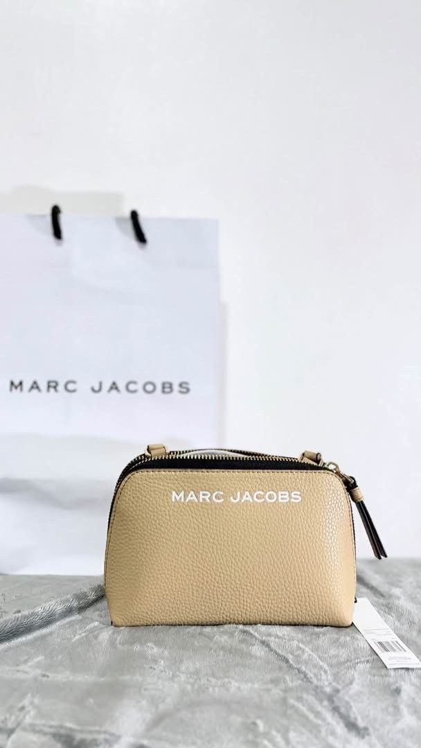 Marc Jacobs Beige Crossbody Bag (Category: Luxury Bags & Wallets) located in Las Pinas. Submitted by raebelran (Listing ID 1471037579, Image 1). Description: - Authentic Marc Jacobs crossbody bag - Color: Beige leather with striking black zipper detail - Branding: Distinctive white logo lettering on the front - Design: Practical double compartment with secure zip closure - Condition: Brand new with store tag attached - Inclusion: Comes with origi