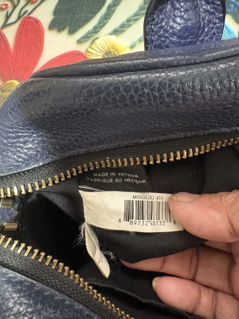 Marc Jacobs Navy Blue Leather Handbag (Category: Luxury Bags & Wallets) located in Cainta. Submitted by goldenpink (Listing ID 1470936917, Image 3). Description: - Brand: Marc Jacobs - Style: Pebbled Leather Satchel - Color: Navy Blue with Gold-toned hardware - Included: Detachable black and white striped guitar strap - Features: Dual top handles, top zip closure, interior tag with barcode and product number (M0008282 415) - Origin: Made in Vietn