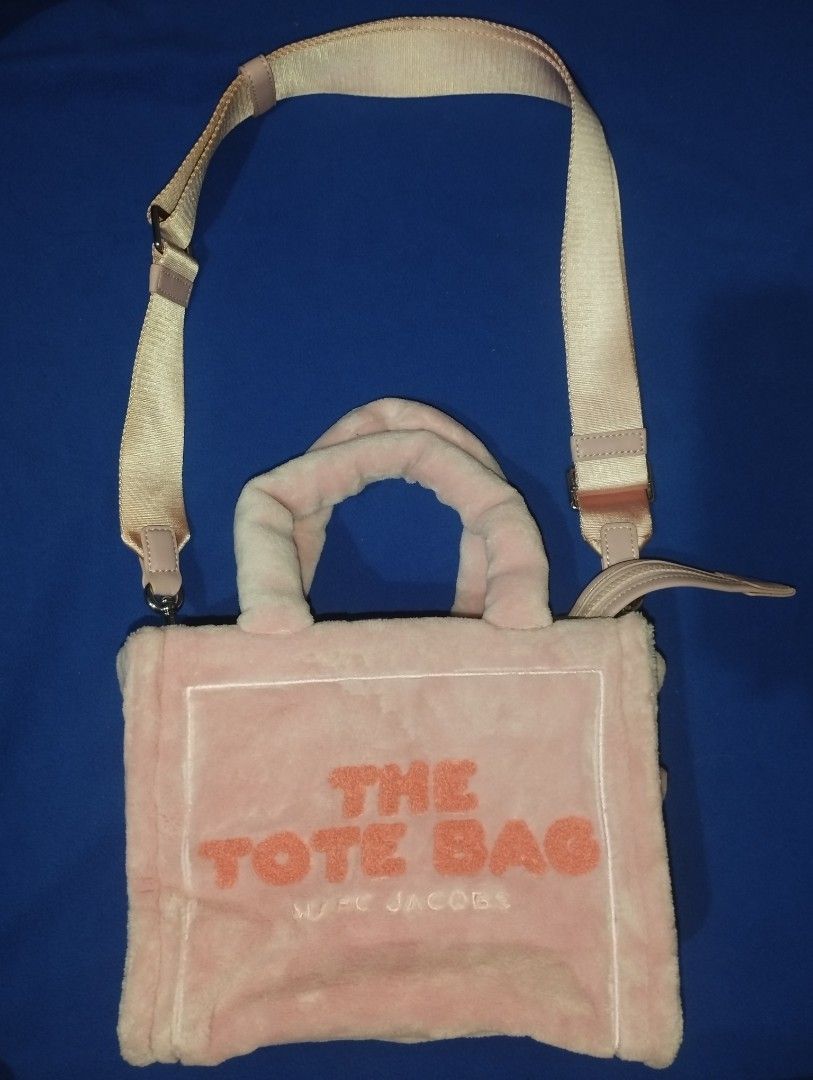 Marc Jacobs The Terry Small Tote Bag Pink (Category: Luxury Bags & Wallets) located in Muntinlupa City. Submitted by beckster_online_luxuryshop (Listing ID 1471076472, Image 1). Description: - Style: Marc Jacobs Tote Bag - Material: Soft pink fluffy fabric with bold orange lettering NEGO - Handles: Double top handles and an adjustable, removable shoulder strap - Closure: Secure top zipper for the spacious main compartment - Interior: Includes off
