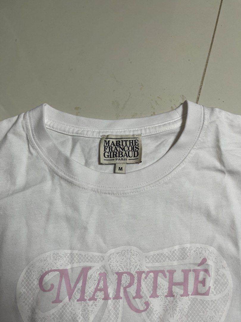 Marithe Francois Girbaud Pink Bow T-shirt (Category: Shirts) located in Manila. Submitted by halukays (Listing ID 1470986813, Image 3). Description: - Brand: Marithé François Girbaud - Style: White tee with pink lettering and lace bow graphic - Size: M - Material: Super soft cotton blend - Condition: Worn a few times, no stains or flaws - Versatile streetwear piece that goes with everything Size Small-Medium (Womens) Width 17.5 Length 17.5 Color 