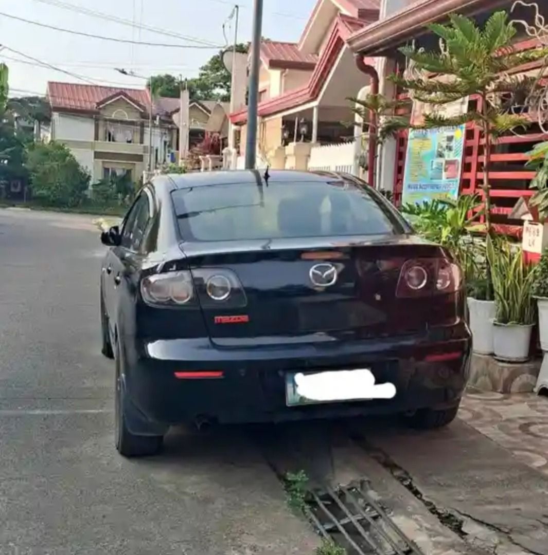 Mazda 3 1.6 (A) (Category: Used Cars) located in Caloocan City. Submitted by norma_ortiz22 (Listing ID 1470946990, Image 3). Description: Mazda 3 Sedan - 2010 - 1.6 Automatic - ₱150,000 For sale: Mazda 3 Sedan, black na may red interior. Details: Taon: 2010 Engine: 1.6L gasoline Transmission: Automatic Mileage: 98,250 km Kulay: Black (exterior), Red (interior) Features: Black mags Red grille accent Window visors Red seat covers Kondisyon: Good ru