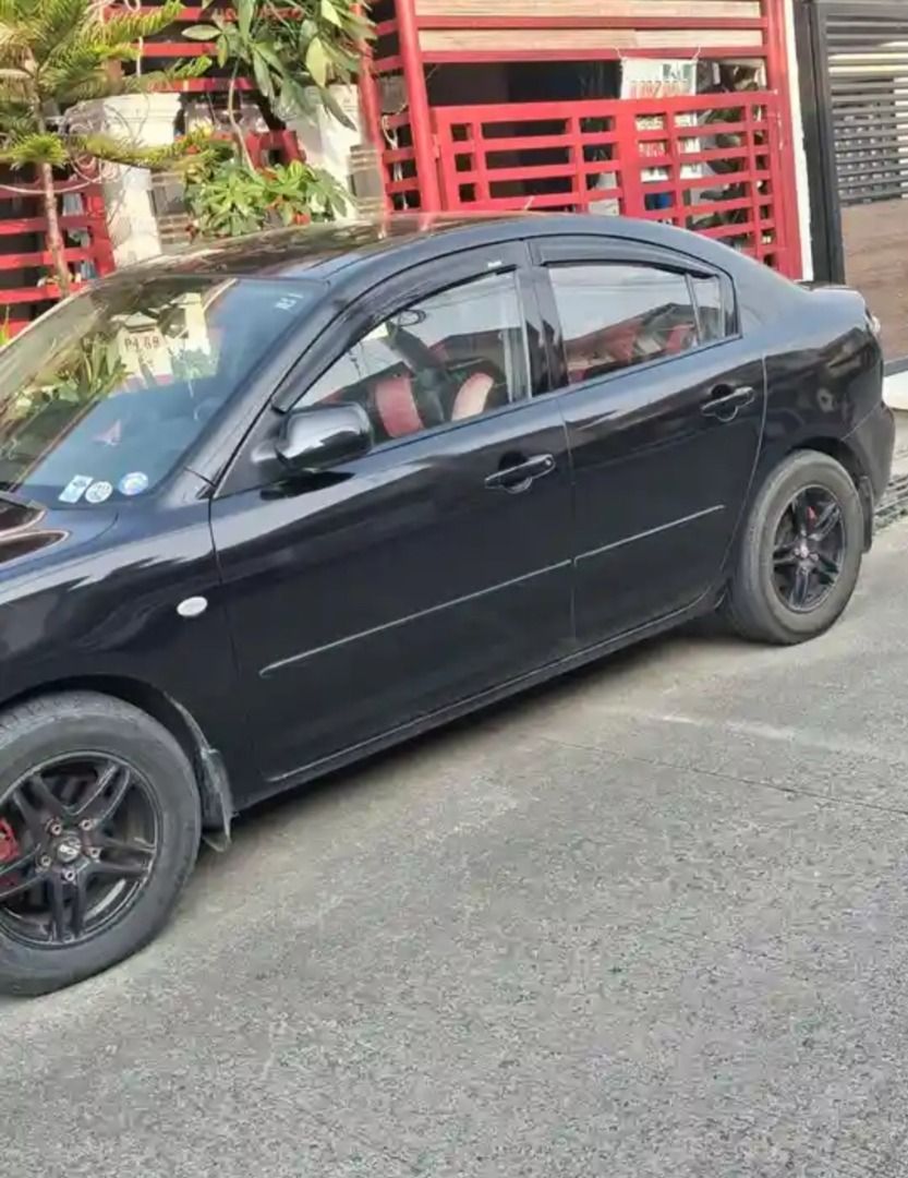 Mazda 3 1.6 (A) (Category: Used Cars) located in Caloocan City. Submitted by norma_ortiz22 (Listing ID 1470946990, Image 2). Description: Mazda 3 Sedan - 2010 - 1.6 Automatic - ₱150,000 For sale: Mazda 3 Sedan, black na may red interior. Details: Taon: 2010 Engine: 1.6L gasoline Transmission: Automatic Mileage: 98,250 km Kulay: Black (exterior), Red (interior) Features: Black mags Red grille accent Window visors Red seat covers Kondisyon: Good ru