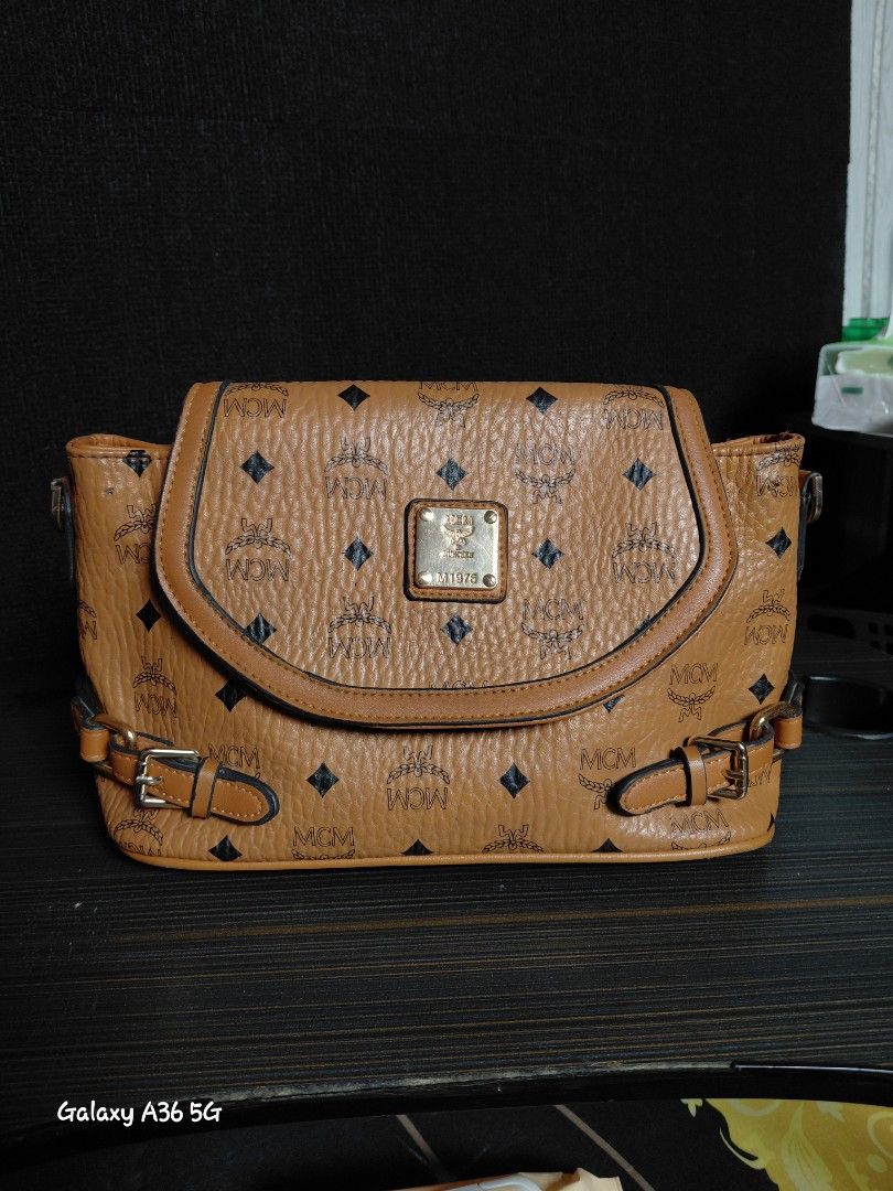 MCM Cognac Visetos Monogram Crossbody Bag (Category: Luxury Bags & Wallets) located in Baguio. Submitted by tabuzomaria1422 (Listing ID 1470978564, Image 1). Description: - Brand: MCM - Color: Classic cognac brown with all-over monogram print - Hardware: Premium gold-tone with front logo plaque - Interior: Fabric-lined with 1 zip pocket and slip compartments - Closure: Secure snap button on front flap - Condition: Excellent / Well-maintained - Mo