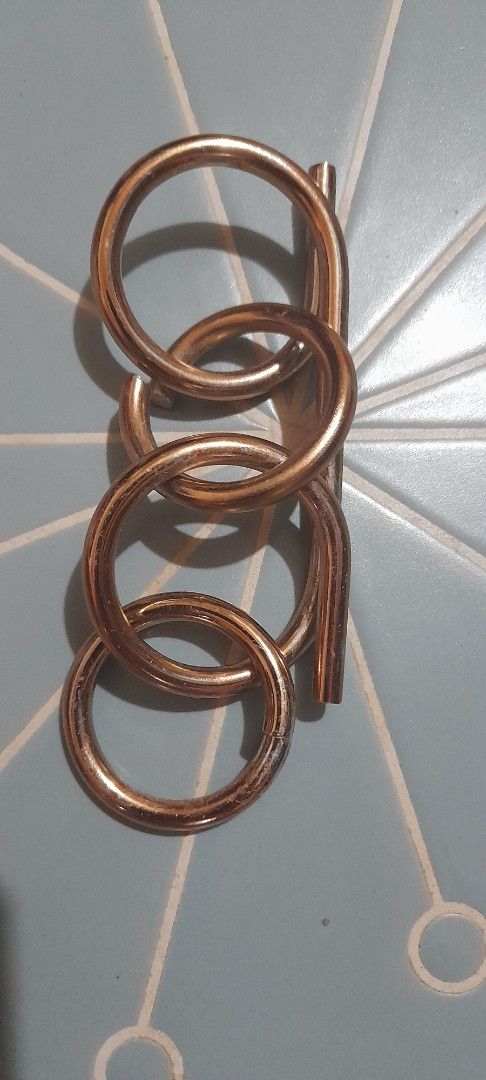 Metal wire puzzle brain teaser game interlocking rings (Category: Board Games & Puzzles) located in Bocaue. Submitted by marajapansurplus (Listing ID 1470972774, Image 2). Description: - Gold-toned metal wire puzzle - Interlocking rings and bar design - Solid metal build with a satisfying weight - Great brain teaser for puzzle lovers and game nights - Goal is to solve by separating the pieces.