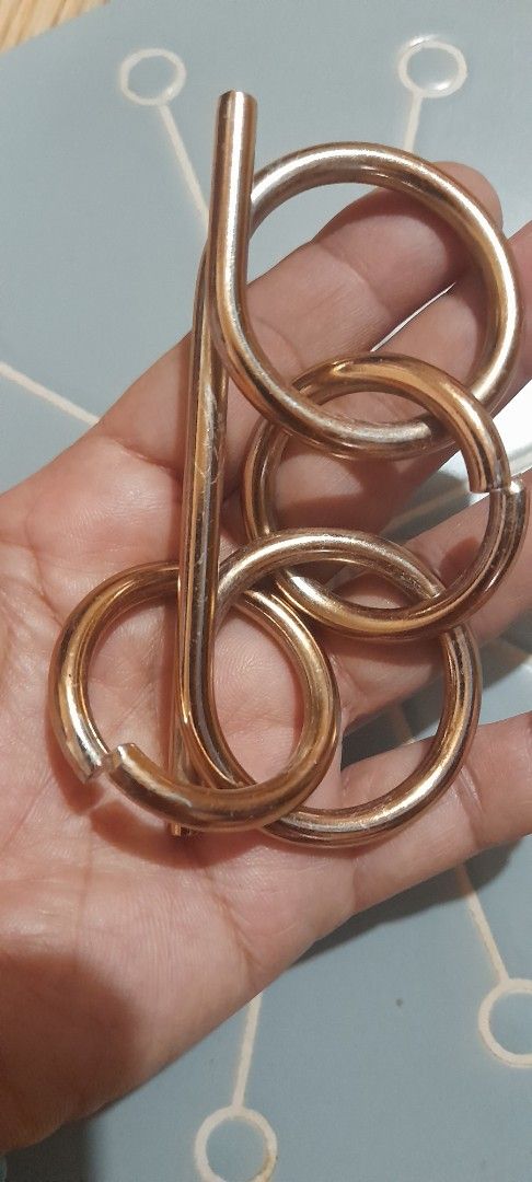 Metal wire puzzle brain teaser game interlocking rings (Category: Board Games & Puzzles) located in Bocaue. Submitted by marajapansurplus (Listing ID 1470972774, Image 3). Description: - Gold-toned metal wire puzzle - Interlocking rings and bar design - Solid metal build with a satisfying weight - Great brain teaser for puzzle lovers and game nights - Goal is to solve by separating the pieces.