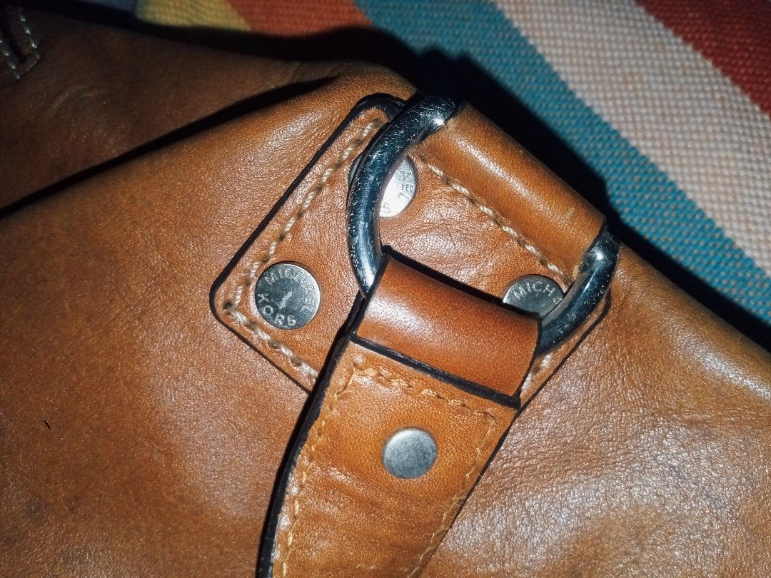 Michael Kors Brown Leather Studded Shoulder Bag (Category: Luxury Bags & Wallets) located in Manila. Submitted by littlelove25 (Listing ID 1471096652, Image 3). Description: - Brand: Michael Kors - Color: Tan Brown - Material: Genuine Leather with Silver Hardware Studs - Closure: Secure Zip Top - Interior: MK Monogram Lining with Multiple Slip Pockets & 1 Zip Pocket - Origin: Made in China Tag Intact - Condition: Excellent everyday bag with plent