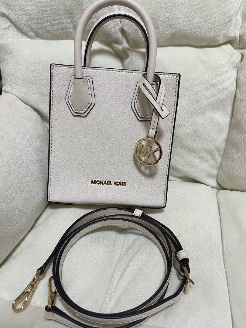 Michael Kors Mini Tote Bag White with Crossbody Strap (Category: Luxury Bags & Wallets) located in Quezon City. Submitted by missymich20 (Listing ID 1471008070, Image 2). Description: - Brand: Michael Kors - Material: White pebble leather with gold hardware - Design: Mini tote with signature MK logo charm - Straps: Double top handles and adjustable, detachable crossbody strap - Interior: MK monogram fabric lining with a small slip pocket and meta