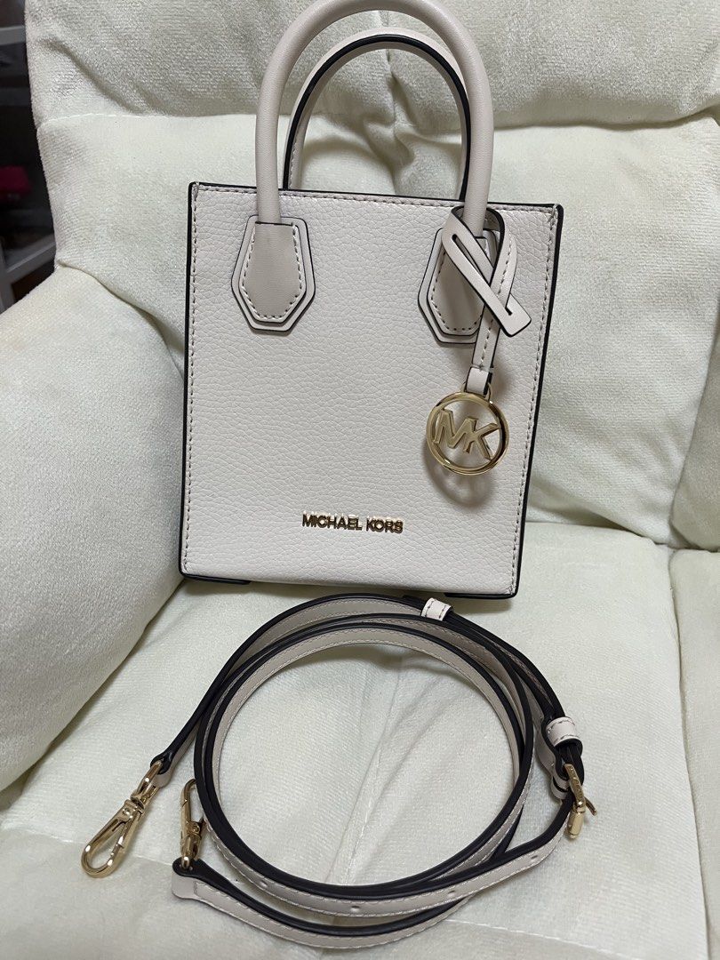 Michael Kors Mini Tote Bag White with Crossbody Strap (Category: Luxury Bags & Wallets) located in Quezon City. Submitted by missymich20 (Listing ID 1471008070, Image 1). Description: - Brand: Michael Kors - Material: White pebble leather with gold hardware - Design: Mini tote with signature MK logo charm - Straps: Double top handles and adjustable, detachable crossbody strap - Interior: MK monogram fabric lining with a small slip pocket and meta