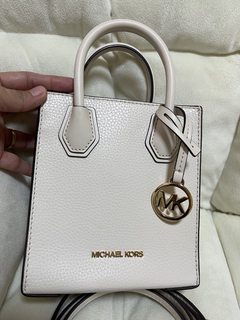 Michael Kors Mini Tote Bag White with Crossbody Strap (Category: Luxury Bags & Wallets) located in Quezon City. Submitted by missymich20 (Listing ID 1471008070, Image 3). Description: - Brand: Michael Kors - Material: White pebble leather with gold hardware - Design: Mini tote with signature MK logo charm - Straps: Double top handles and adjustable, detachable crossbody strap - Interior: MK monogram fabric lining with a small slip pocket and meta