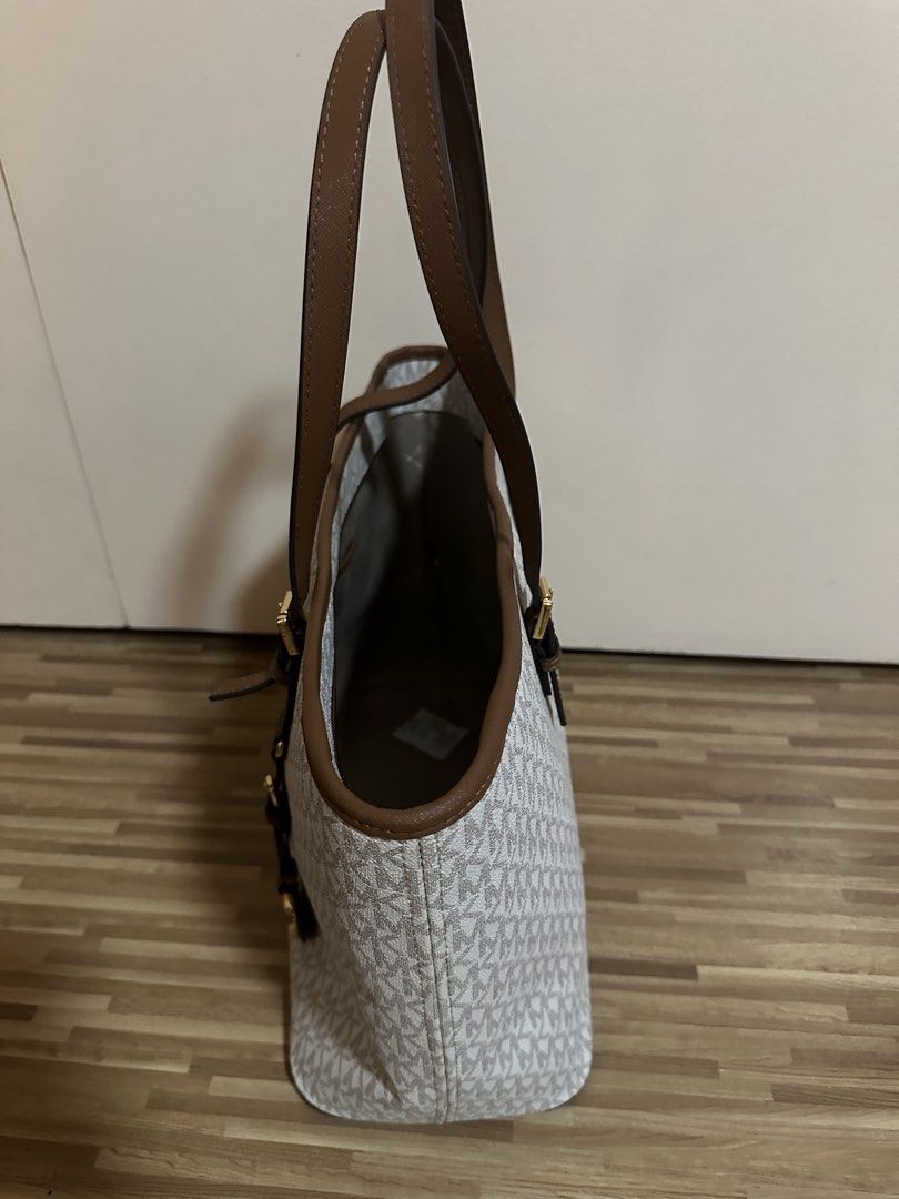 Michael Kors MK Monogram Tote Bag Brown White (Category: Tote Bags) located in San Juan City. Submitted by luluhonolulu (Listing ID 1471081587, Image 3). Description: - Authentic Michael Kors tote bag in classic white/grey monogram - Elegant brown leather handles, trim, and gold-tone hardware - Includes signature hanging MK logo charm - Secure zip-top closure - Spacious interior featuring open slip pockets and a key leash strap - Structured, self