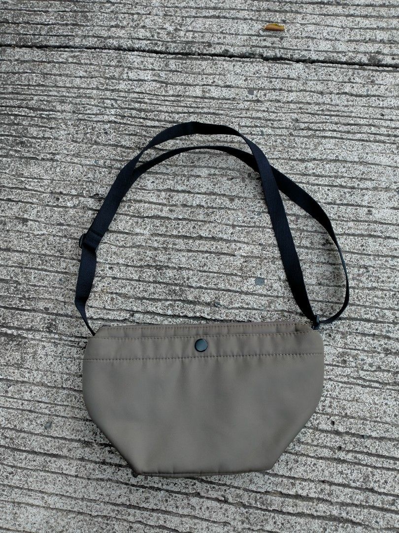 Minimalist Crossbody Bag with Adjustable Black Strap (Category: Cross-body Bags) located in Davao. Submitted by ervinpolino09 (Listing ID 1471013063, Image 1). Description: Uniqlo Nylon Sling Bag - Material: Smooth, durable nylon - Strap: Adjustable black strap - Closure: Secure top zip - Pockets: Small front pocket with dark snap button - Design: Curved structured bottom with clean stitching - Style: Simple and versatile everyday carryall.