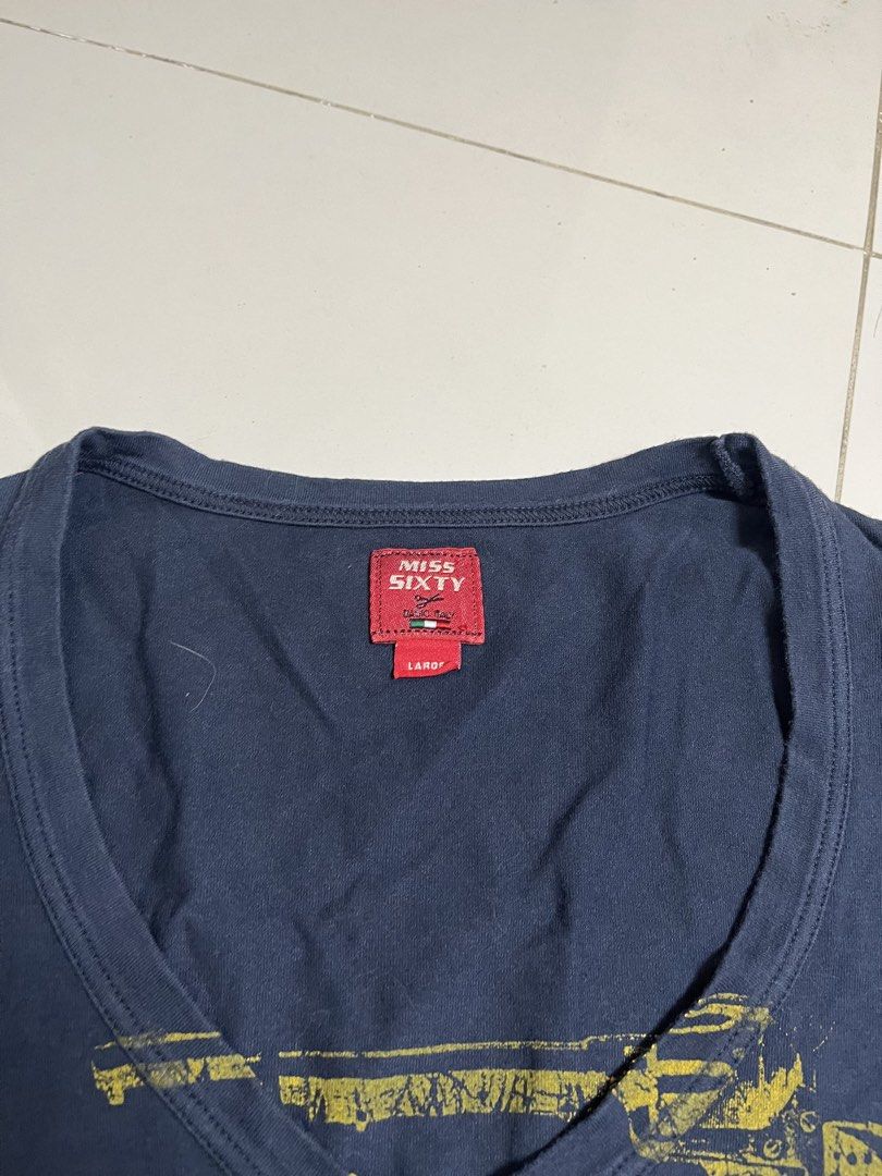 Miss Sixty Navy Long Sleeve Graphic Tee (Category: Longsleeves) located in Manila. Submitted by halukays (Listing ID 1470986613, Image 3). Description: - Brand: Miss Sixty (Made in Italy) - Color: Navy blue with yellow graphic chest print - Design: Gun illustration and "1960 meets miss sixty hollywood golden years western wear" text - Details: Scoop neckline, signature red brand tags on collar and sleeve cuff - Size: Large - Condition: Excellent 