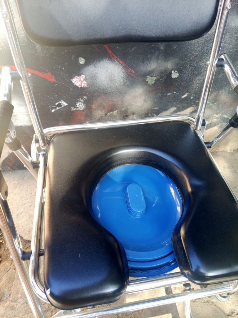 Mobile Commode Chair with Wheels and Removable Bucket (Category: Medical Supplies & Tools) located in Manila. Submitted by warmcrystal_269010 (Listing ID 1470993457, Image 2). Description: - Material: Durable stainless steel frame - Comfort: Black padded seat, backrest, and armrests - Convenience: Includes blue removable commode bucket with lid - Mobility: 4 smooth-rolling wheels for easy movement around the house - Support: Built-in footrest for