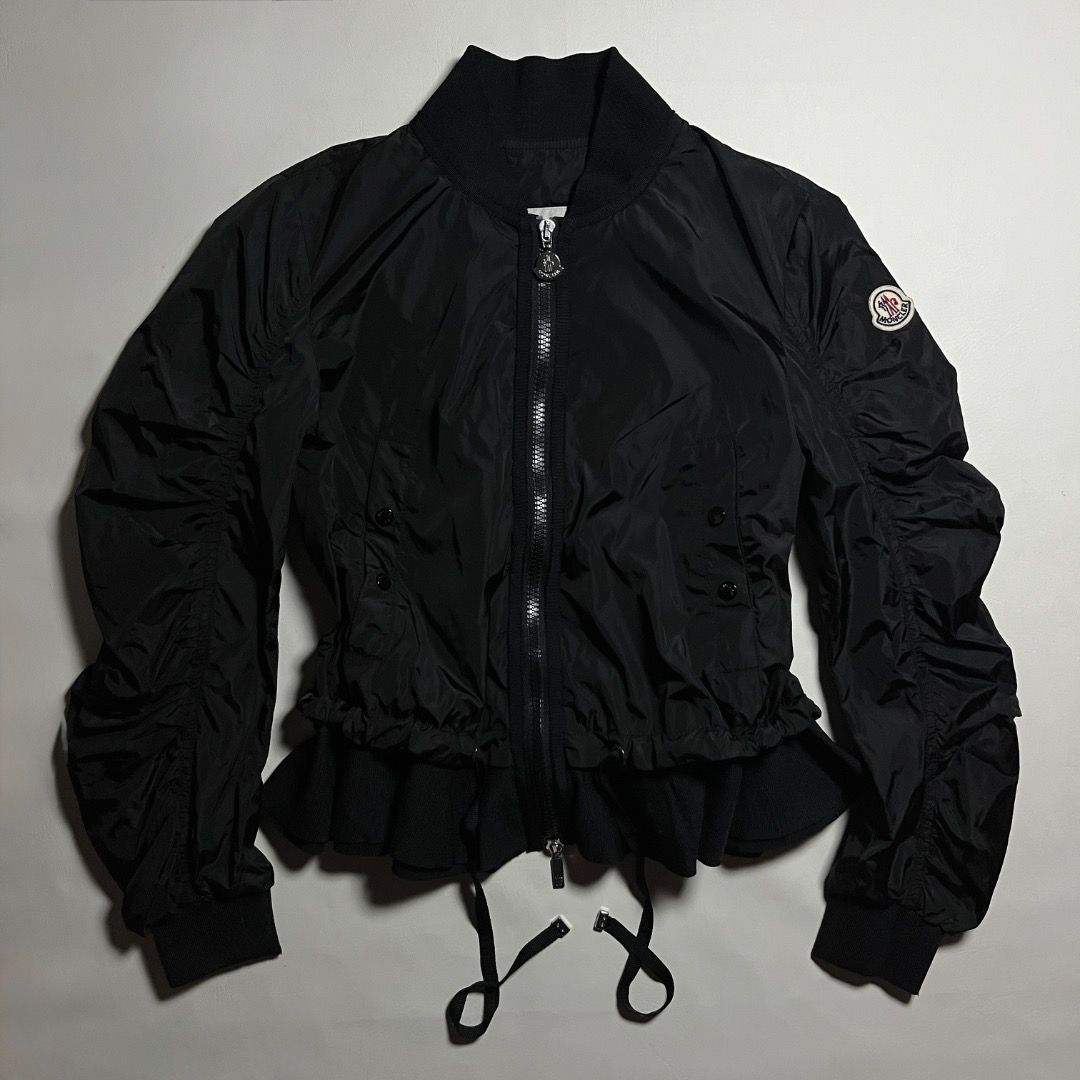 Moncler Black Bomber Jacket Ruffled Hem (Category: Coats, Jackets and Outerwear) located in Caloocan City. Submitted by achilles_grails (Listing ID 1471046678, Image 1). Description: - Authentic Moncler black nylon bomber jacket - Full zip front closure with branded metallic hardware - Classic ribbed collar and cuffs with trendy ruched sleeves - Practical button-flap front pockets - Unique ruffled knit hem with adjustable drawstrings for a custom