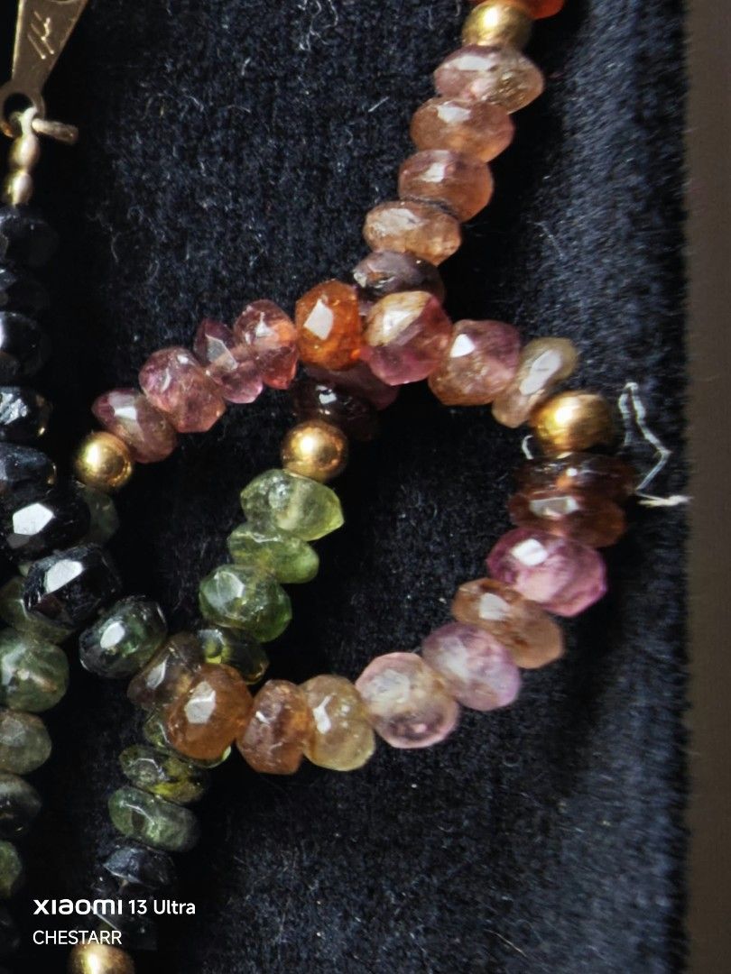 Multicolor Tourmaline Beaded Necklace with Box (Category: Necklaces) located in Cauayan City . Submitted by chestarrprelovedauthentic (Listing ID 1470969353, Image 2). Description: - Beautiful multicolor tourmaline faceted beads with a stunning color gradient from black to vibrant pinks, oranges, and greens - Enhanced with elegant gold-toned metal beads and small spacers - Features a secure clasp with a small Japanese hallmark stamp - Standard ne