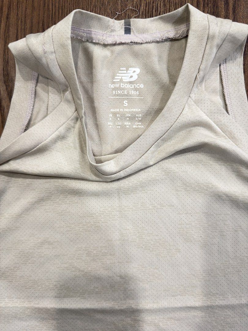 New Balance Running Tank Top Size S (Category: Activewear) located in Angeles City. Submitted by beyond.this (Listing ID 1470985770, Image 2). Description: - Brand: New Balance - Color: Beige - Size: S (US/EU S, JP M, AU 5/10) - Origin: Made in Indonesia - Material: Lightweight, breathable athletic fabric - Design: Scoop neckline, sleeveless, side slits at the hem, and small logo near the bottom corner - Condition: Brand new with tags.