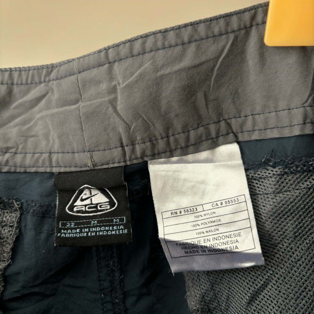 Nike ACG Navy Nylon Cargo Shorts Size 32 (Category: Shorts) located in Bambang. Submitted by heats777 (Listing ID 1471010957, Image 3). Description: - Brand/Line: Nike ACG - Item: Nylon cargo shorts - Color: Dark navy blue - Size: 32 (Medium) - Material: 100% polyamide (lightweight & quick-drying) - Features: Multiple functional pockets on front and back - Origin: Made in Indonesia - Condition: Clean, excellent overall condition.