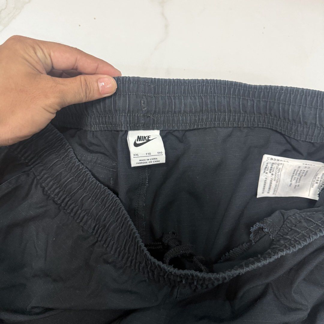 Nike Cargo Shorts Black Size 2XL (Category: Shorts) located in Caloocan City. Submitted by ayogorenia1002 (Listing ID 1471030808, Image 3). Description: - Brand/Model: Nike Cargo Shorts - Size: XXL - Color: Black - Material: Cotton with ripstop texture - Waistband: Elastic with internal drawstring - Pockets: Utility cargo pockets on both sides - Details: Small white embroidered Nike logo near the left pocket - Condition: Clean overall.