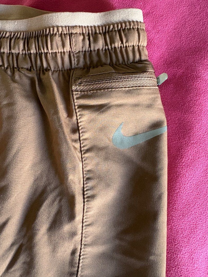 Nike Dri-FIT Running Shorts (Category: Activewear) located in Cainta. Submitted by PreLovedbyANM (Listing ID 1471001518, Image 2). Description: - Brand: Nike - Style: Dri-FIT running shorts - Color: Terracotta / Clay - Size: Medium (M) - Waistband: Elastic with adjustable 'Nike Running' drawstring - Logo: Reflective silver Swoosh on the front - Storage: Convenient zippered pocket on the right hip - Two inner small pockets at back & front - Suppor