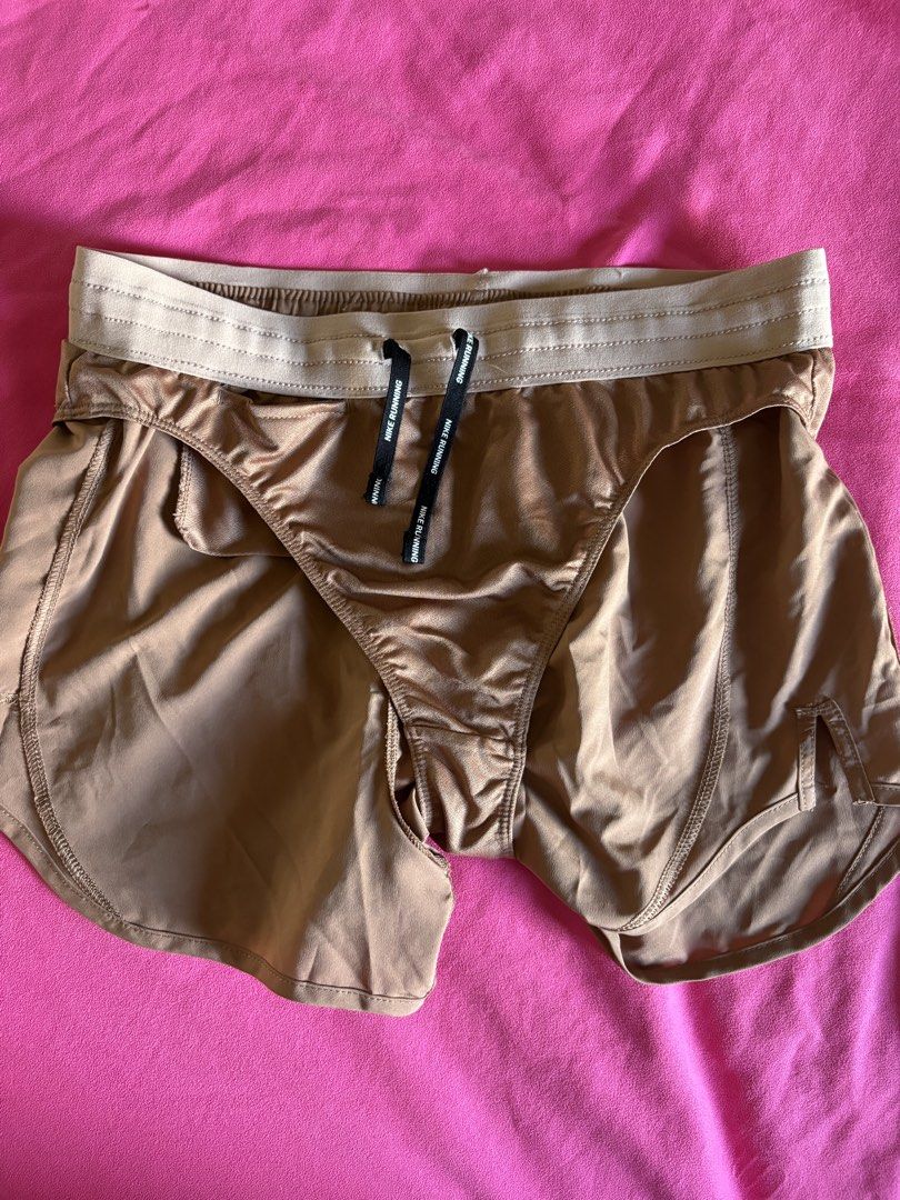 Nike Dri-FIT Running Shorts (Category: Activewear) located in Cainta. Submitted by PreLovedbyANM (Listing ID 1471001518, Image 3). Description: - Brand: Nike - Style: Dri-FIT running shorts - Color: Terracotta / Clay - Size: Medium (M) - Waistband: Elastic with adjustable 'Nike Running' drawstring - Logo: Reflective silver Swoosh on the front - Storage: Convenient zippered pocket on the right hip - Two inner small pockets at back & front - Suppor