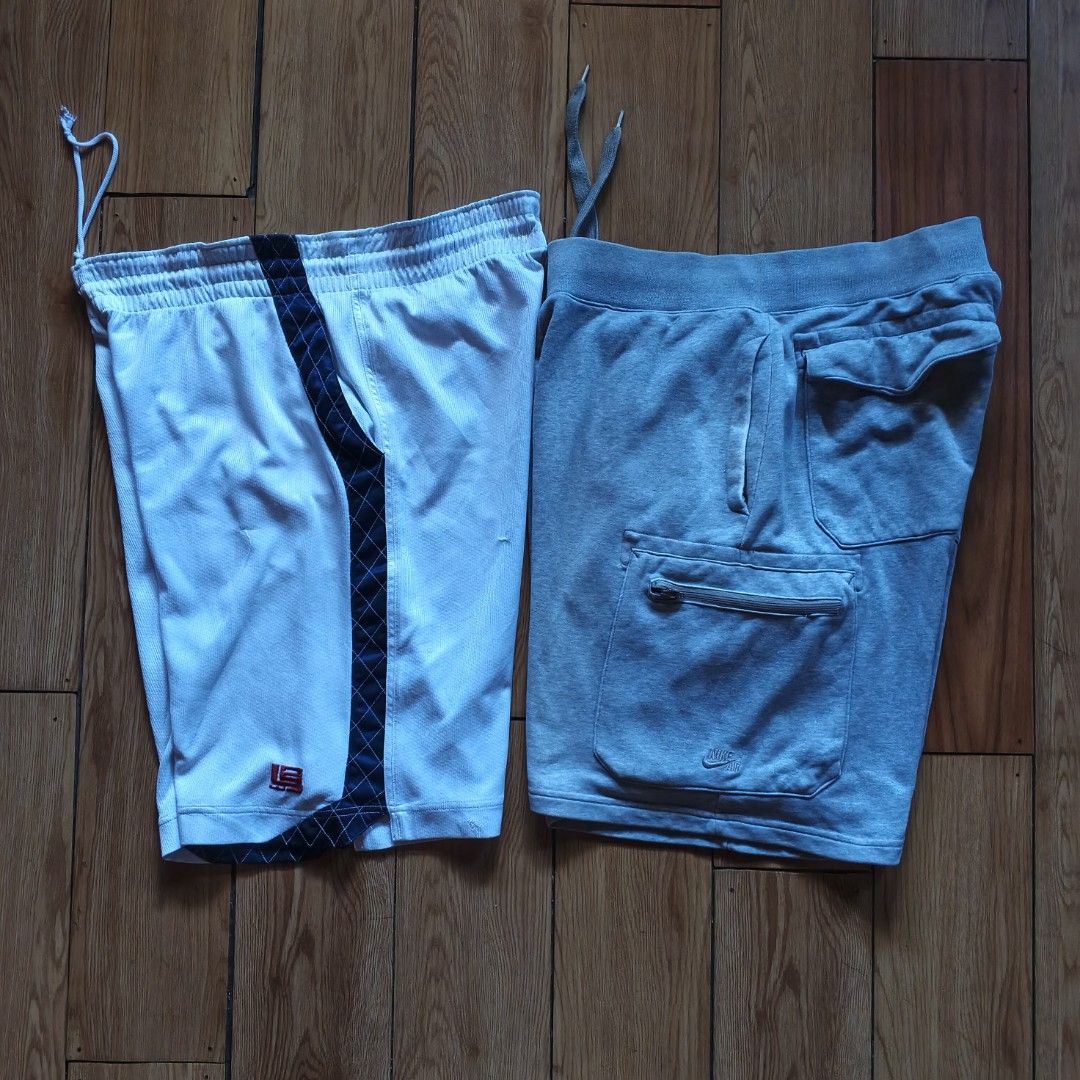 Nike LeBron and Nike Air Shorts Bundle (Category: Shorts) located in Paranaque City. Submitted by thriftine5 (Listing ID 1470991957, Image 1). Description: - Size: XL - Material: Cotton & polyester blend - Pair 1: White mesh LeBron James shorts with navy blue stripe and functional pockets - Pair 2: Grey fleece Nike Air shorts with cargo pockets and elastic drawstring waist - Features: Both pairs have functional pockets and adjustable waistbands -