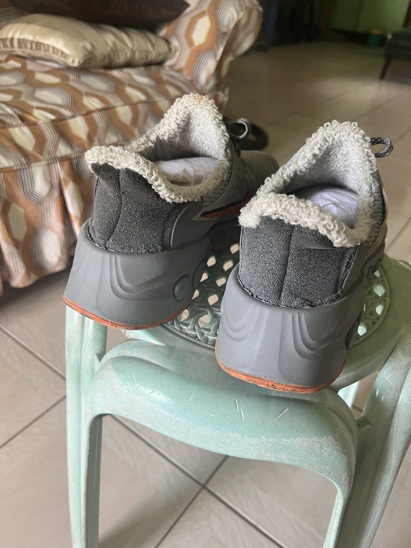 Nike Sneakers for Men (Category: Sneakers) located in Quezon City. Submitted by trisha_1998 (Listing ID 1470962070, Image 3). Description: - Color: Gray with vibrant orange swoosh detailing - Comfort: Warm fleece inner lining for colder days - Sole: Thick gray midsole with circular indentations and classic waffle traction - Closure: Lace-up design with matching gray laces - Features: Dark gray heel panel with a convenient pull tab - Condition: So