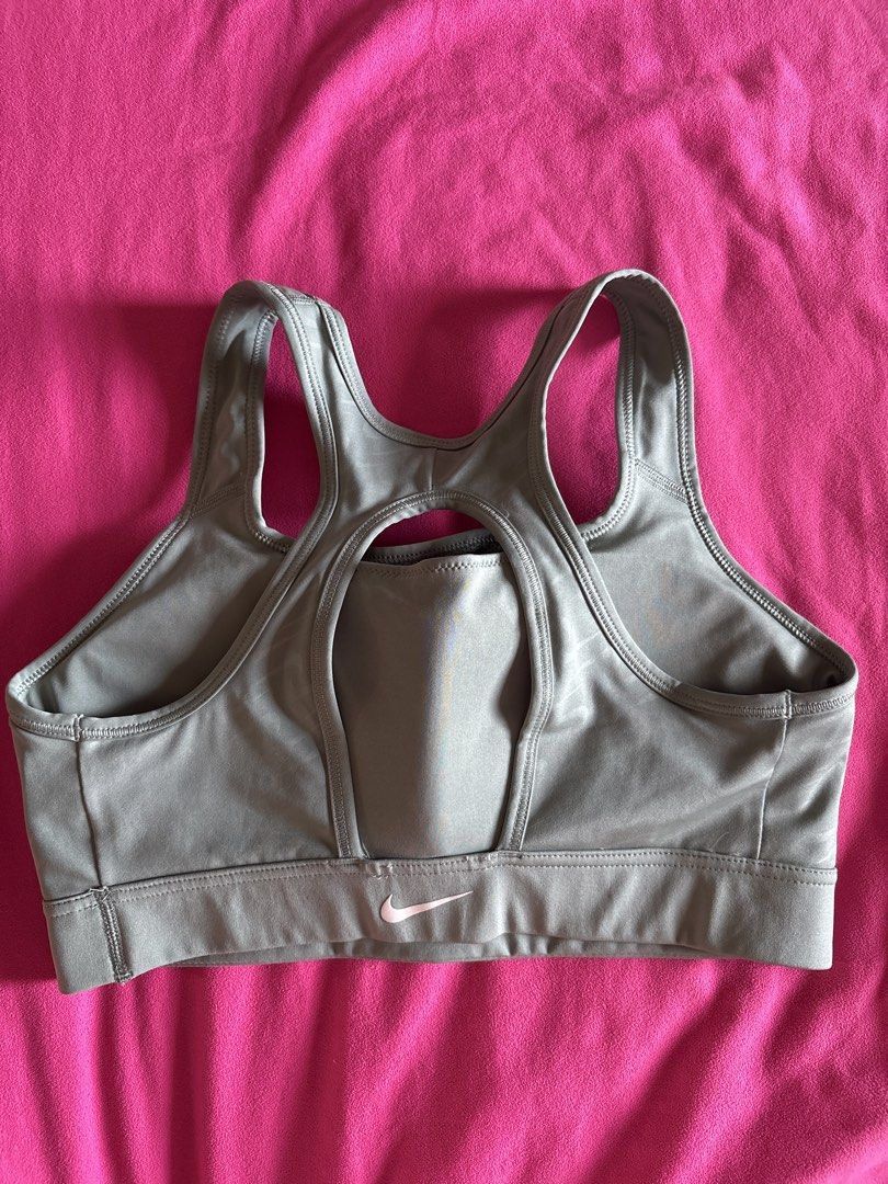 Nike Sports Bra (Category: Activewear) located in Cainta. Submitted by PreLovedbyANM (Listing ID 1471015781, Image 2). Description: - Brand: Nike - Color: sage / greenish gray - Size: Large - Technology: Dri-FIT fabric keeps you dry and cool - Design: Racerback with a stylish keyhole cutout - Band: Comfortable elastic underband featuring a pink Nike swoosh logo on the back Worn once Issue - stitch at the back (see pic) Rfs - too tight for me No C