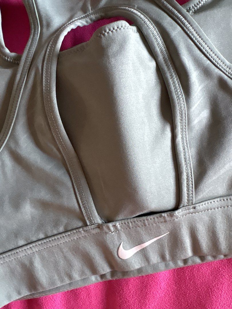 Nike Sports Bra (Category: Activewear) located in Cainta. Submitted by PreLovedbyANM (Listing ID 1471015781, Image 3). Description: - Brand: Nike - Color: sage / greenish gray - Size: Large - Technology: Dri-FIT fabric keeps you dry and cool - Design: Racerback with a stylish keyhole cutout - Band: Comfortable elastic underband featuring a pink Nike swoosh logo on the back Worn once Issue - stitch at the back (see pic) Rfs - too tight for me No C