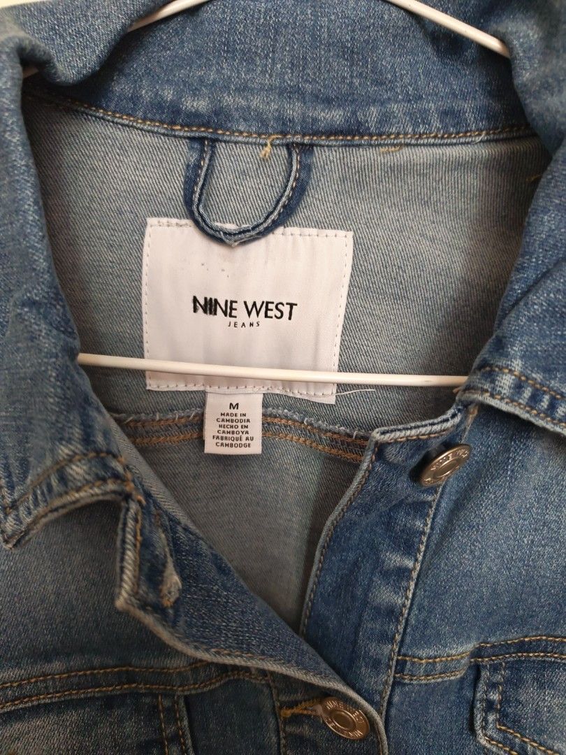 Nine West Denim Jacket Size M (Category: Coats, Jackets and Outerwear) located in Marikina City. Submitted by jennyfromtheblock15 (Listing ID 1470946631, Image 1). Description: - Brand: Nine West - Size: Medium - Color: Classic blue wash - Material: Sturdy cotton blend denim - Features: Button-up front with branded hardware, chest pockets, buttoned cuffs - Fit: Adjustable hem tabs on the back - Condition: Excellent, timeless everyday outerwear.