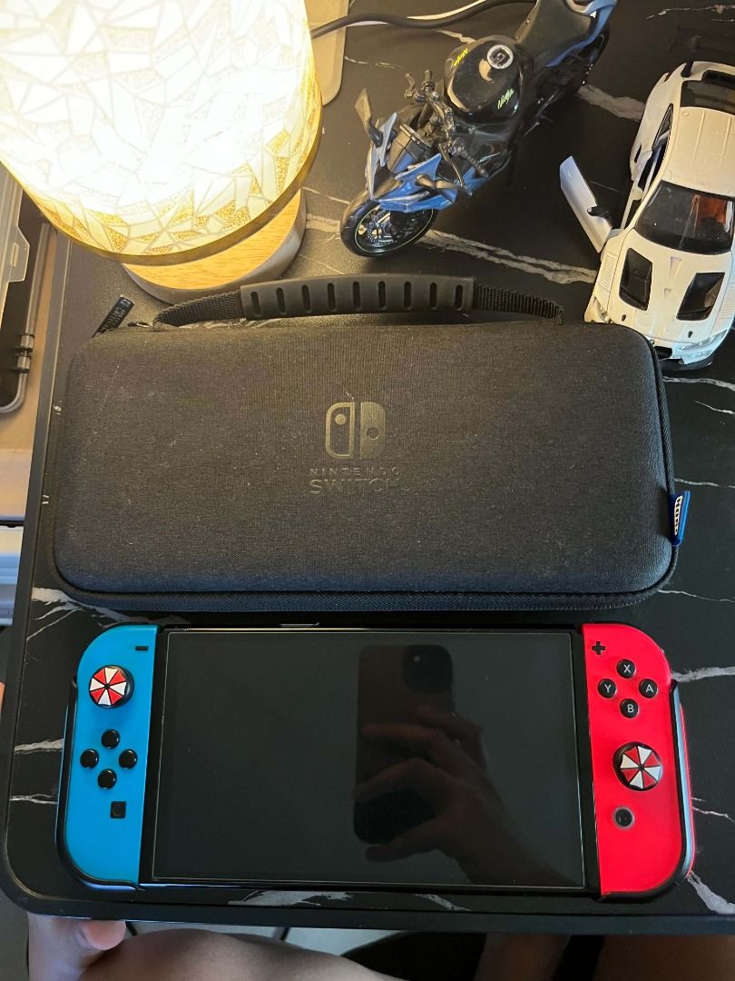 Nintendo Switch OLED Neon Blue and Red Console (Category: Nintendo) located in Caloocan City. Submitted by grandmountain.58b9fc (Listing ID 1471046664, Image 1). Description: Nintendo Switch handheld console with Neon Blue/Red Joy-Cons, custom umbrella thumb grips, black protective case, and screen protector. Fully functional for both portable and docked play. Ready to use! Note: Unit and charger only!!.