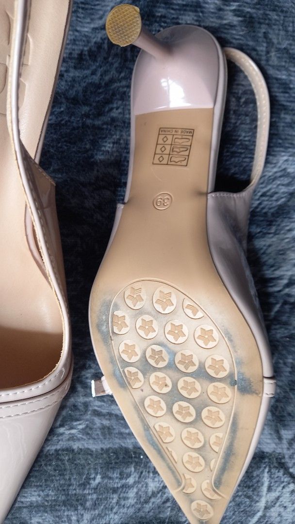 Nude Pointed Slingback Stiletto Size 39 (Category: Heels) located in Manila. Submitted by miss66449 (Listing ID 1470980533, Image 3). Description: - Style: Nude patent slingback heels with pointed toe - Size: 39 - Features: Chic buckle strap detail, sleek stiletto heel with protective tip - Condition: Clean and glossy upper material, minor wear on bottom soles from light indoor use used once. .