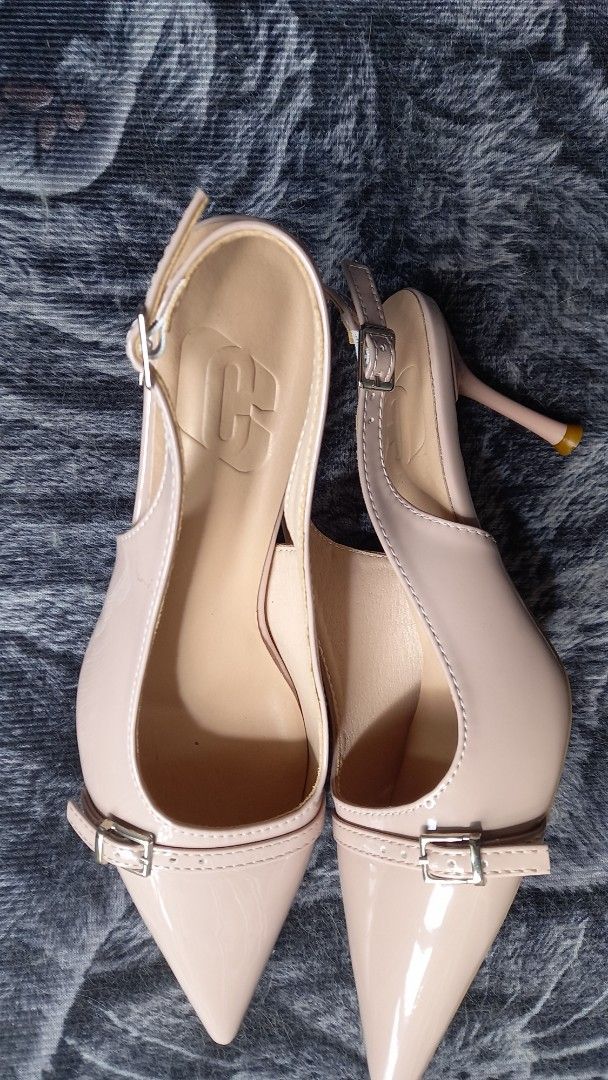 Nude Pointed Slingback Stiletto Size 39 (Category: Heels) located in Manila. Submitted by miss66449 (Listing ID 1470980533, Image 2). Description: - Style: Nude patent slingback heels with pointed toe - Size: 39 - Features: Chic buckle strap detail, sleek stiletto heel with protective tip - Condition: Clean and glossy upper material, minor wear on bottom soles from light indoor use used once. .