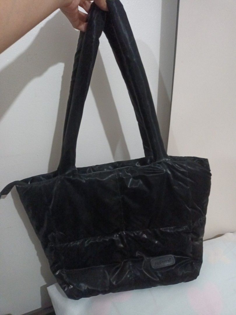 NuPrene Black Puffer Tote Bag (Category: Tote Bags) located in Quezon. Submitted by ja8720 (Listing ID 1471052006, Image 2). Description: - Brand: NuPrene - Color: Black with a glossy finish - Design: Quilted puffer with stitched panels - Features: Dual shoulder straps, secure zippered top closure, and front logo patch - Capacity: Roomy interior ideal for daily essentials or travel.