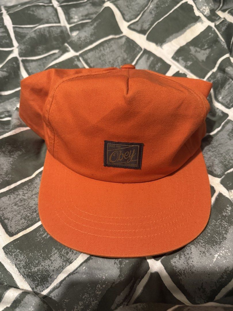 Obey orange snapback cap (Category: Caps & Hats) located in Manila. Submitted by safeowl.b6dbb0 (Listing ID 1471023861, Image 2). Description: - Brand: Obey - Style: Snapback cap with flat brim and structured crown - Color: Bright orange with front logo patch - Material: 100% cotton (Made in Bangladesh) - Features: Interior mesh front panel and adjustable snap closure - Size: One size fits all - Condition: Brand new.