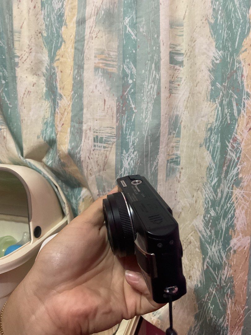 Panasonic Lumix DMC-LX2 Compact Digital Camera (Category: Cameras) located in Caloocan City. Submitted by arkleii2112 (Listing ID 1471030797, Image 3). Description: Black Panasonic Lumix DMC-LX2 compact camera. Zoom lens extends nicely. Mode dial on top, rear LCD screen, and dedicated joystick control. Serial number sticker on the base reads EP7JA02782 R. Standard wrist strap attached. Takes SD memory cards. Battery door clicks shut securely. Gre