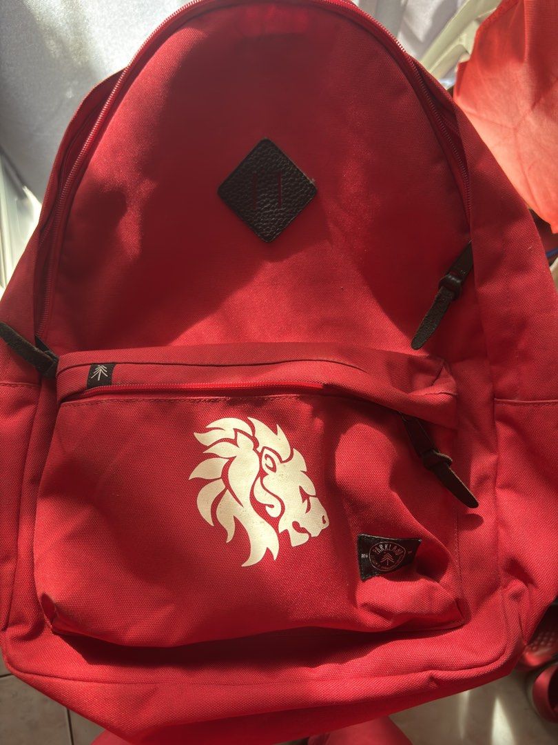 Parkland Red Backpack with Lion Graphic (Category: Backpacks) located in Santa Rosa. Submitted by heckler03 (Listing ID 1471001133, Image 1). Description: - Brand/Model: Parkland backpack in bright red - Design: Large white lion graphic on front pocket with classic brand tag - Storage: Main compartment with internal laptop sleeve and front zipper pocket - Comfort: Padded shoulder straps with adjustable plastic sliders - Details: Stylish diamond p