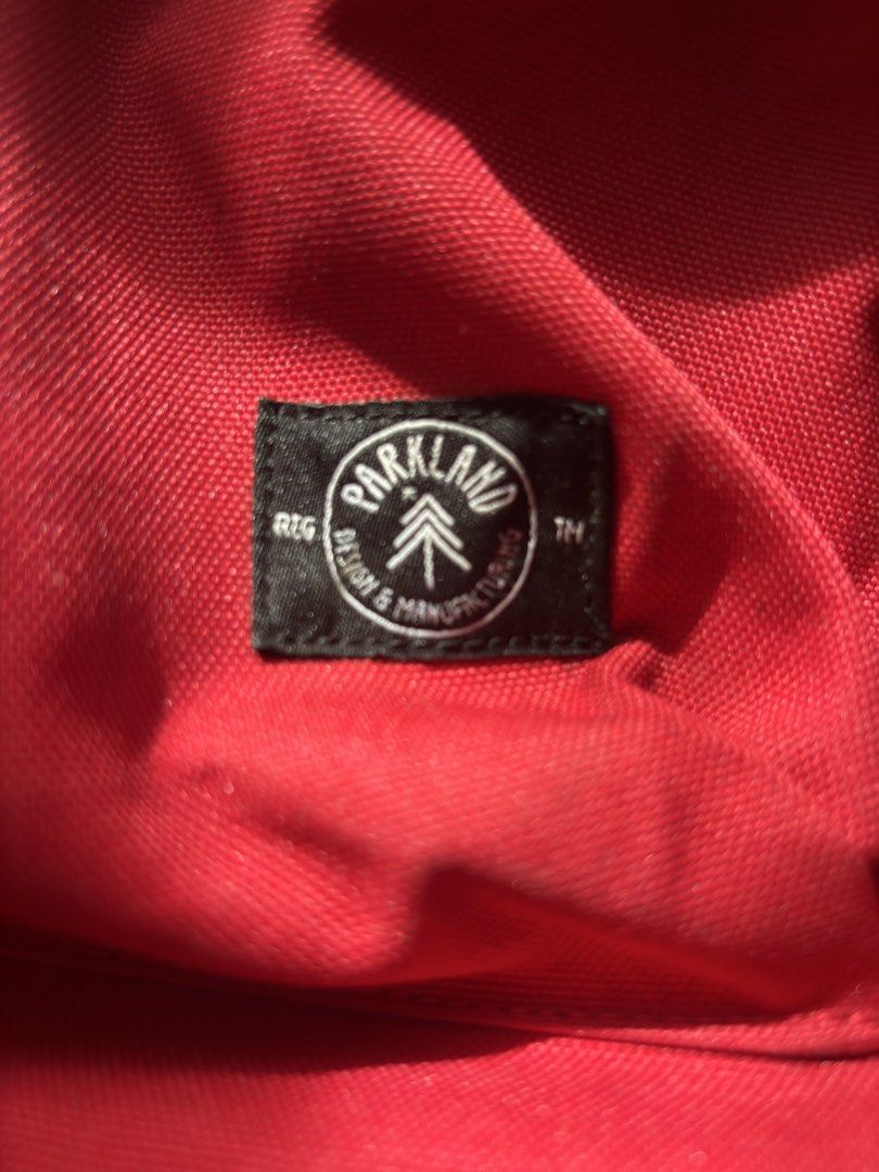 Parkland Red Backpack with Lion Graphic (Category: Backpacks) located in Santa Rosa. Submitted by heckler03 (Listing ID 1471001133, Image 2). Description: - Brand/Model: Parkland backpack in bright red - Design: Large white lion graphic on front pocket with classic brand tag - Storage: Main compartment with internal laptop sleeve and front zipper pocket - Comfort: Padded shoulder straps with adjustable plastic sliders - Details: Stylish diamond p