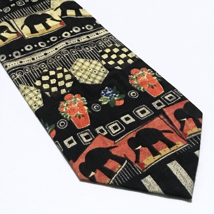 Parksdea Vintage Hand Made Collage Pattern Black Neck Tie (Category: Ties) located in Taguig. Submitted by retrogaze (Listing ID 1471030174, Image 2). Description: This vintage handmade necktie by Parksdea features a solid black base printed with an eclectic, artistic collage pattern arranged in horizontal registers. The design combines stylized elephant silhouettes framed in warm terracotta-orange, cream, and mustard blocks, paired with checkere