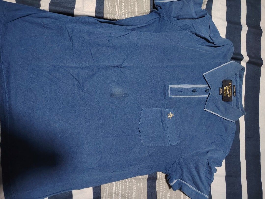 Penguin (Category: Tshirts & Polo Shirts ) located in Manila. Submitted by snooks1938 (Listing ID 1471096700, Image 3). Description: - Brand: Original Penguin - Style: Heritage slim fit polo - Color: Blue - Size: Medium - Details: Classic collar, three-button placket, chest pocket with embroidered gold penguin logo - Flaw: Noticeable stain on the front chest area (please check photos) - Origin: Made in China note: A bit of dirt not stain.. need t