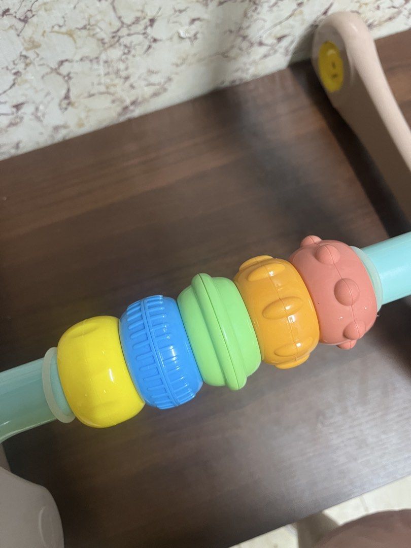People Baby Walker Toy with Beads (Category: Infant Playtime) located in Manila. Submitted by kayerrr.gem (Listing ID 1471048745, Image 2). Description: - Brand: People baby walker toy - Design: Pastel frame with multi-colored spinning beads - Safety & Mobility: Wheels feature rubber grips and adjustable resistance locks - Build: Solid and sturdy to help little ones learn to walk - Condition note: Has some tiny orange marks on the turquoise bar.