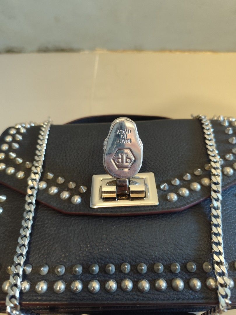 Philipp Plein Black Studded Skull Handbag (Category: Luxury Bags & Wallets) located in Caloocan City. Submitted by zenkithriftsph (Listing ID 1470960158, Image 3). Description: - Authentic black calf leather handbag with striking metal stud detailing - Dual carrying options: silver-tone chain strap and sturdy top handle - Eye-catching rhinestone skull lock closure on the front flap - Interior features durable black polyester patterned lining and 