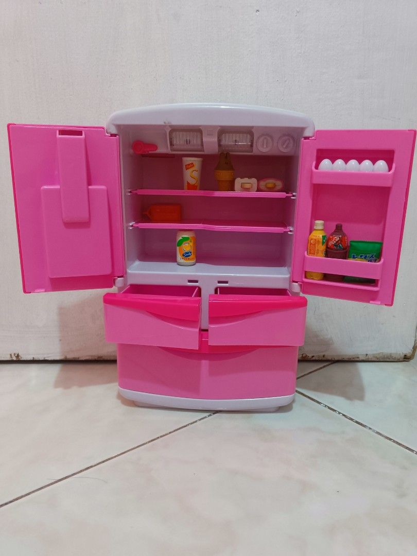 Pink Plastic Toy Refrigerator Playset with Accessories (Category: Kids Toys) located in Manila. Submitted by xxxmateo (Listing ID 1470972287, Image 2). Description: - Adorable pink and white toy refrigerator for kids' playtime - Realistic double-door design with opening bottom freezer drawers - Features a fun pretend water dispenser on the front door - Comes with miniature play food: shake cup, ice cream cone, popsicles, soda cans, snacks, and eg