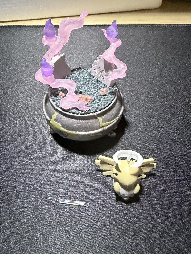 Pokemon Shedinja Ghost Cauldron Diorama Figure (Category: Figurines & Statues) located in Mandaluyong City. Submitted by juliansthings (Listing ID 1471089674, Image 3). Description: - Custom Shedinja figure featuring a spooky cauldron base - Accented with translucent pink and purple ghost flame effects and two tombstones - Detailed weathered pot design with glowing green cracks - Stands upright when assembled properly. Please see 3rd image for th