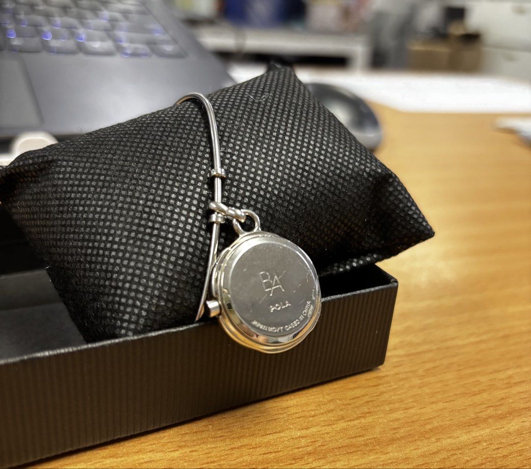Pola Silver Bangle Watch Charm Bracelet (Category: Women's Watches) located in Caloocan City. Submitted by berndale_closet (Listing ID 1470968436, Image 3). Description: - Brand: Pola - Movement: Japan movement (stamped on case back) - Design: Round watch face dangling from a slim metal bracelet - Dial details: Simple hands with a small stone marker at the top - Fit: Adjustable clasp mechanism for easy wearing on the wrist - Style: Silver bangle 