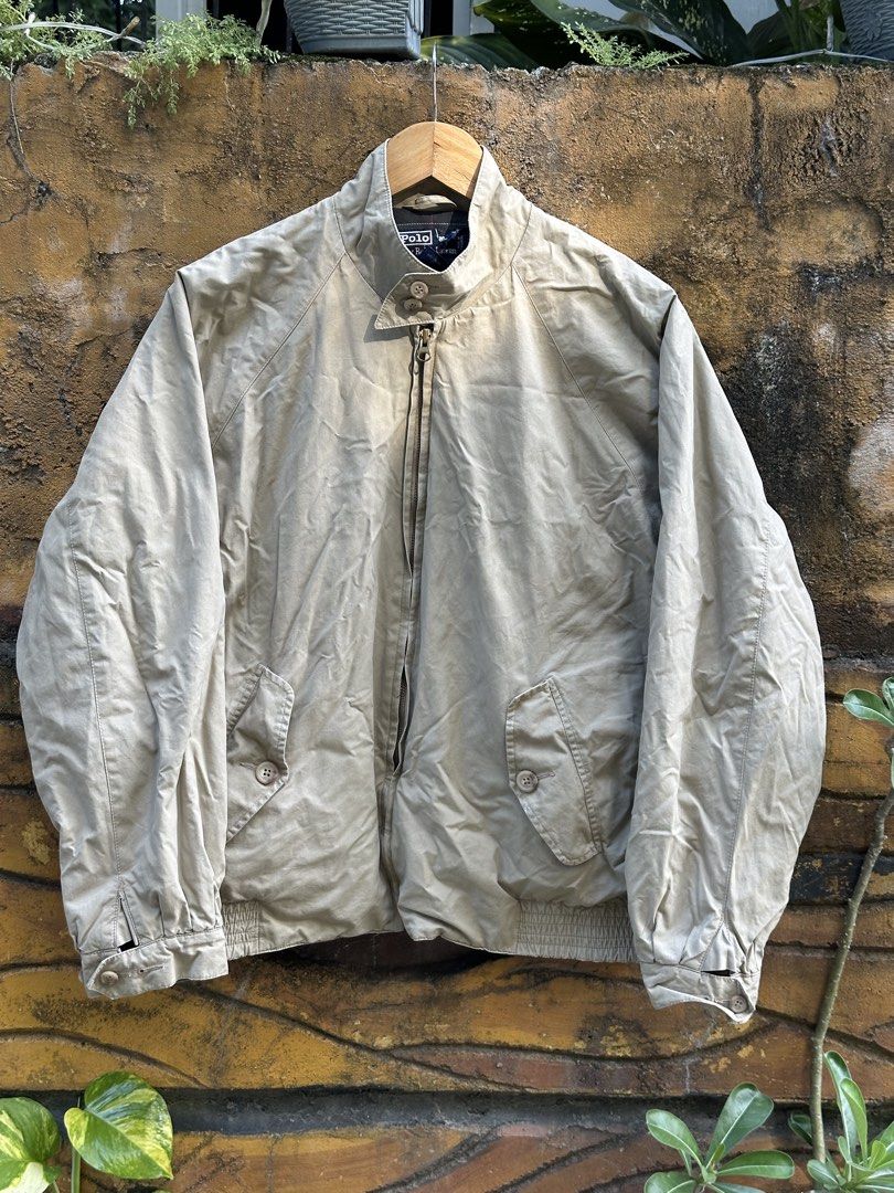 Polo Ralph Lauren Beige Harrington Jacket Plaid Lined (Category: Coats, Jackets and Outerwear) located in Urdaneta. Submitted by redeemedcollective (Listing ID 1471066567, Image 1). Description: Polo by Ralph Lauren Harrington-style jacket in a classic beige/khaki colorway, featuring a navy and green plaid interior lining. • Brand: Polo by Ralph Lauren • Color: Beige / Khaki • Size: Tag not clearly readable • Full front YKK zipper closure • Stand