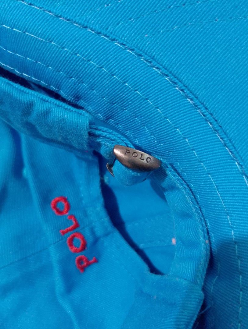 Polo Ralph Lauren Blue Baseball Cap Hat (Category: Caps & Hats) located in Manila. Submitted by thriftyboyzzz (Listing ID 1470998394, Image 3). Description: - Brand: Polo Ralph Lauren - Color: Bright blue with red accents - Design: Embroidered red pony logo on front, red POLO text on back - Material: 100% cotton - Fit: Adjustable metal buckle strap with engraved POLO branding - Condition: Brand new with original tags attached - Origin: Made in Ba