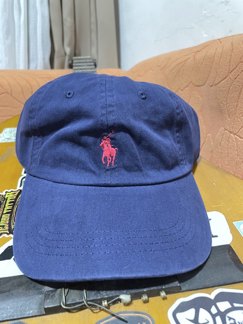 Polo Ralph Lauren Blue Cap (Category: Caps & Hats) located in Manila. Submitted by clementdav22513 (Listing ID 1471025318, Image 1). Description: - Brand: Polo Ralph Lauren - Color: Classic navy blue - Material: 100% cotton - Details: Red embroidered pony logo on front, POLO lettering above back strap - Hardware: Metal buckle with branding - Size: One size fits all (adjustable) - Origin: Made in Vietnam.