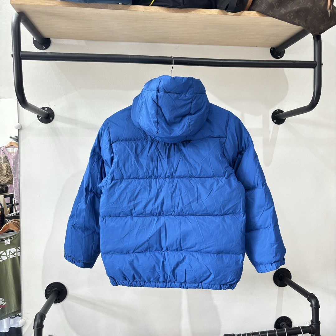 Polo Ralph Lauren Blue Puffer Jacket (Category: Coats, Jackets and Outerwear) located in Bambang. Submitted by heats777 (Listing ID 1471039454, Image 3). Description: - Brand: Polo Ralph Lauren - Color: Bright blue - Material: 100% polyester (quilted design for warmth) - Features: Attached hood, full zip with snap buttons, and two button-flap front pockets - Details: Iconic embroidered pony logo on the chest - Condition: Great outer layer for chi