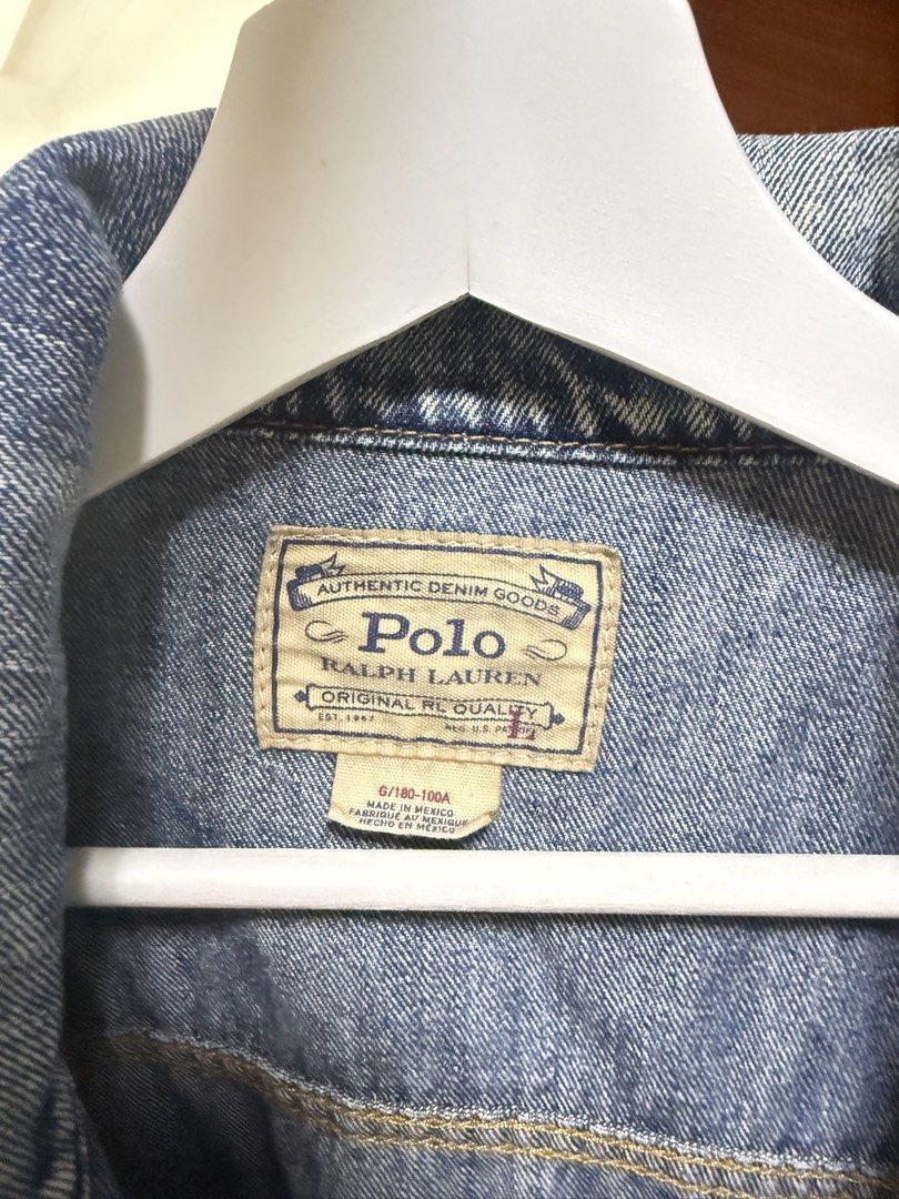 Polo Ralph Lauren Denim Trucker Jacket (Category: Coats, Jackets and Outerwear) located in Mabalacat. Submitted by mykachika (Listing ID 1471087977, Image 2). Description: - Brand: Polo Ralph Lauren - Style: Classic denim jacket with button-up front, chest pockets, and side pockets - Wash: Medium wash - Size: Large (180-100A on tag) - Special Feature: American flag patch on right sleeve with branded metal hardware - Origin: Made in Mexico - Condi
