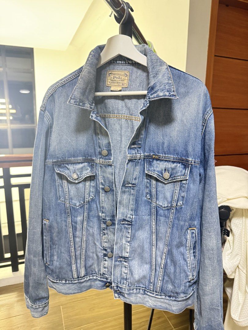 Polo Ralph Lauren Denim Trucker Jacket (Category: Coats, Jackets and Outerwear) located in Mabalacat. Submitted by mykachika (Listing ID 1471087977, Image 1). Description: - Brand: Polo Ralph Lauren - Style: Classic denim jacket with button-up front, chest pockets, and side pockets - Wash: Medium wash - Size: Large (180-100A on tag) - Special Feature: American flag patch on right sleeve with branded metal hardware - Origin: Made in Mexico - Condi